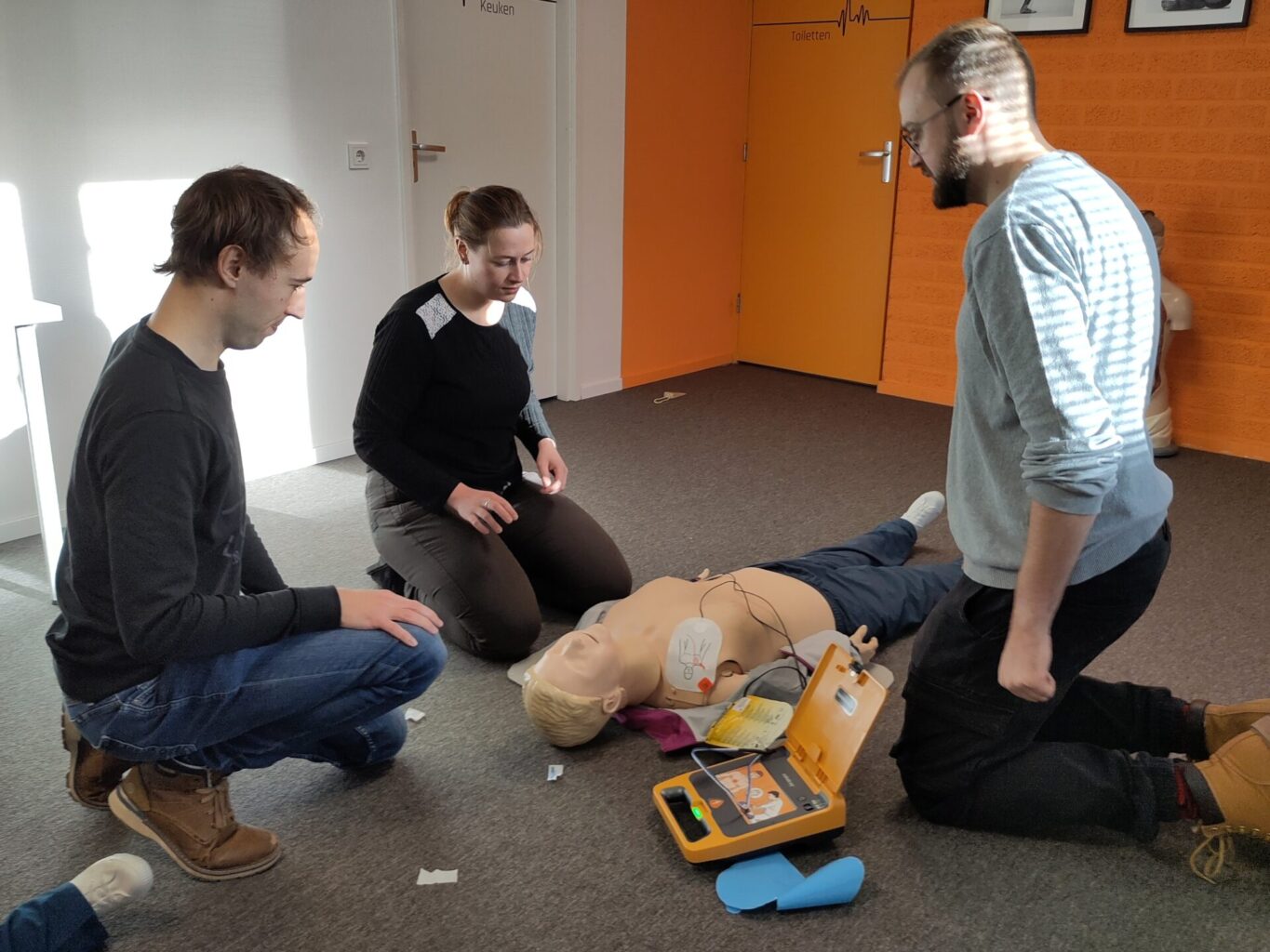 Reanimatieles met 3 cursisten en een pop en een Mindray AED